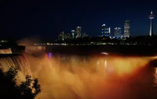 Niagra Falls at night with buildings in the background