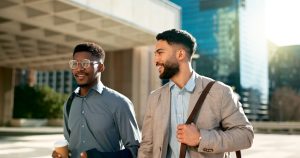 Two men are taking a break from work and stepping outside for their well-being.